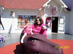 My daughter on a dinosaur, and me pointing.